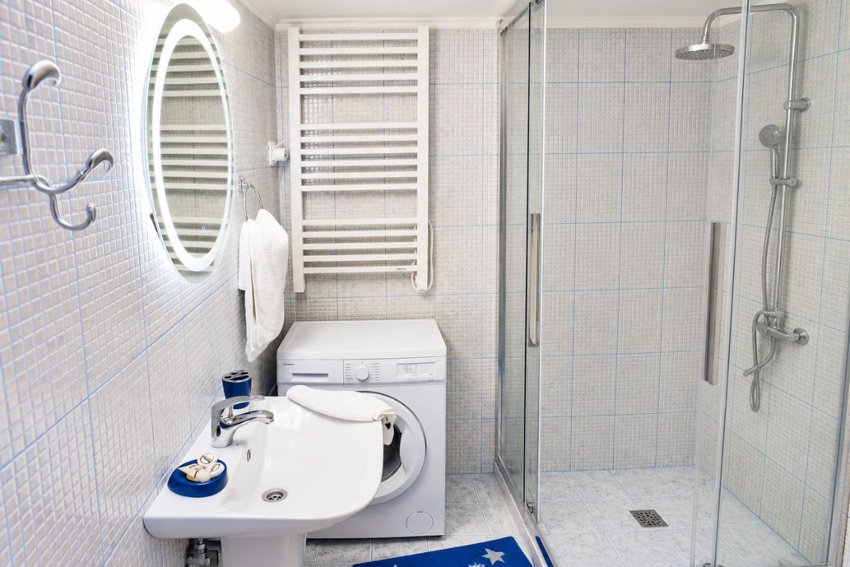 Μοντέρνο μπάνιο στο Patras Blue Suite με ευρύχωρη καμπίνα ντους, πλυντήριο ρούχων, πετσετοκρεμάστρα και πλήρεις παροχές