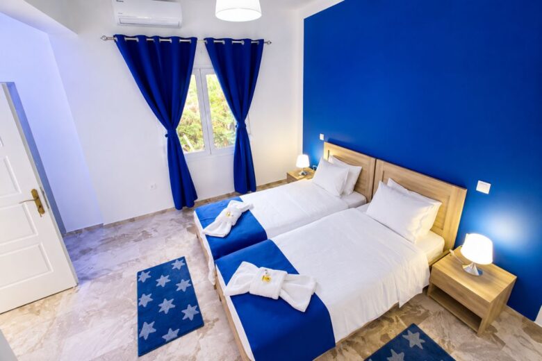 Φωτεινό υπνοδωμάτιο στο Patras Blue Suite με δύο άνετα μονά κρεβάτια, κλιματισμό, μοντέρνα επίπλωση και κομψές μπλε λεπτομέρειες