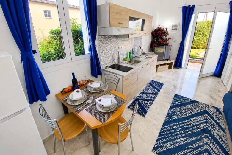 Μοντέρνα κουζίνα και τραπεζαρία στο Patras Blue Suite με πλήρως εξοπλισμένη κουζίνα, φωτεινό καθιστικό και άμεση πρόσβαση στον κήπο