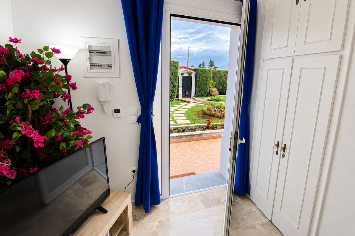 Εσωτερικός χώρος του Patras Blue Suite με τηλεόραση, ντουλάπα και άμεση πρόσβαση στον ιδιωτικό κήπο