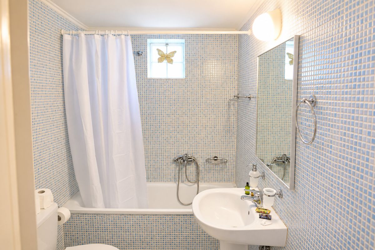 Καθαρό και φωτεινό μπάνιο στο Patras Cozy Lodge με μπανιέρα, νιπτήρα και σύγχρονες παροχές