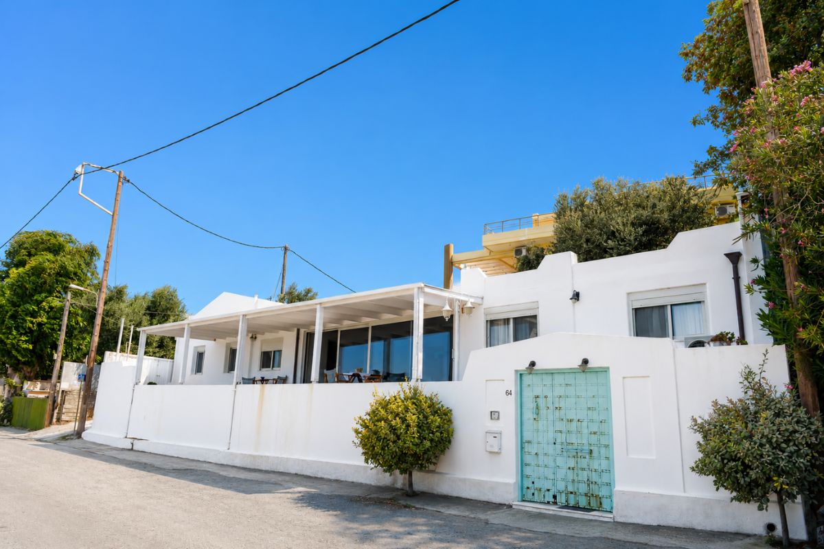 Εξωτερική όψη λευκής βίλας με τιρκουάζ πύλη στο Patras Luxury Seaside House, Πάτρα